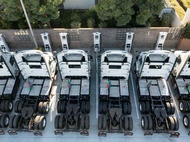 A row of commercial vehicles charging at a charging station