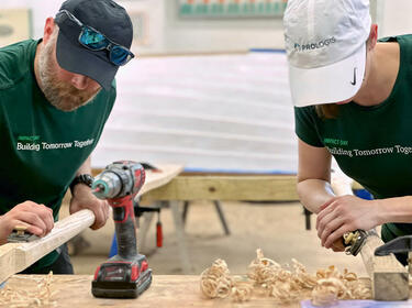 Two Prologis employees sanding wood at an IMPACT day project